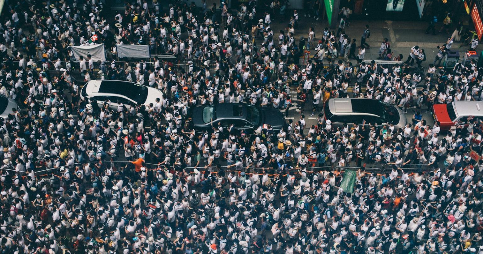 aerial photography of four cars surrounded with people